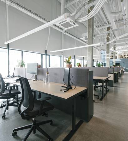 Inside shot of new open space office with colorful furniture on workplace and light from windows